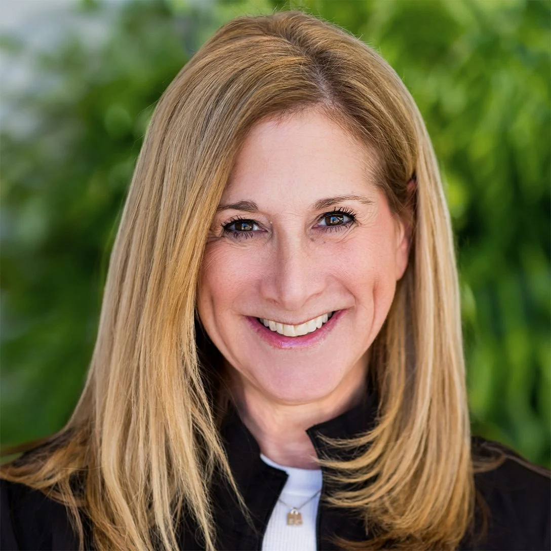 Alexandra Frascino, MS, LMFT-S, smiling portrait in front of greenery, Clinical Director at All Points North DFW, emphasizing the importance of staff in addiction treatment and rehabilitation services.